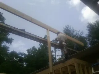 Carpenter setting a ridge beam over a new addition frame — Ice Dam Removal by Roofing Brothers in Mount Hamilton