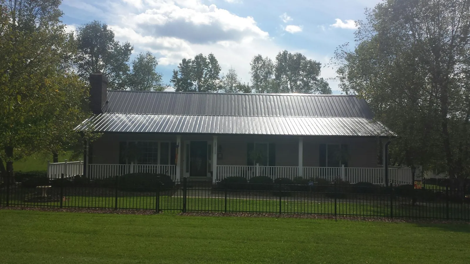 Gray metal roof on a brick ranch with a full width front porch — Gutter Guard Installation work by our crew in Mount Hamilton